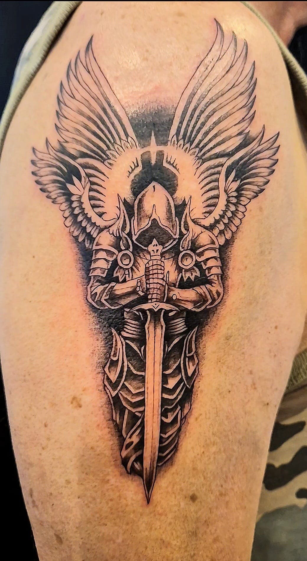 Saint Michel en armure tatoué en réalisme noir et gris sur le bras