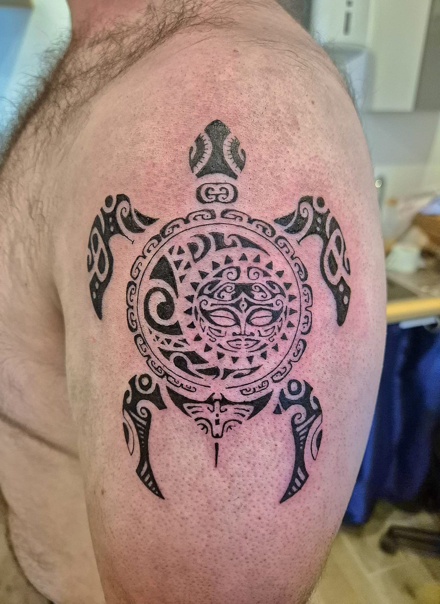 Tatouage polynésien maori, tortue et soleil marquisien sur l'épaule