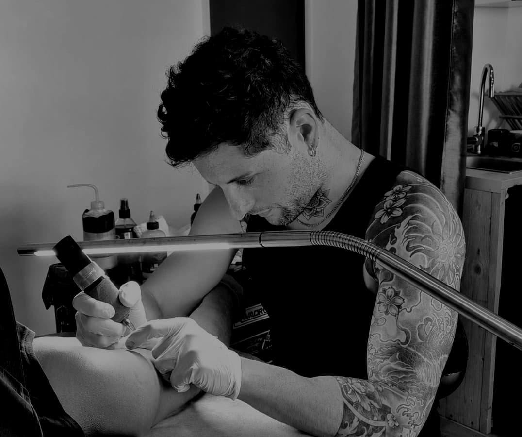 Victor, tatoueur à Gruissan, en train de tatouer une ligne fine sur un avant-bras